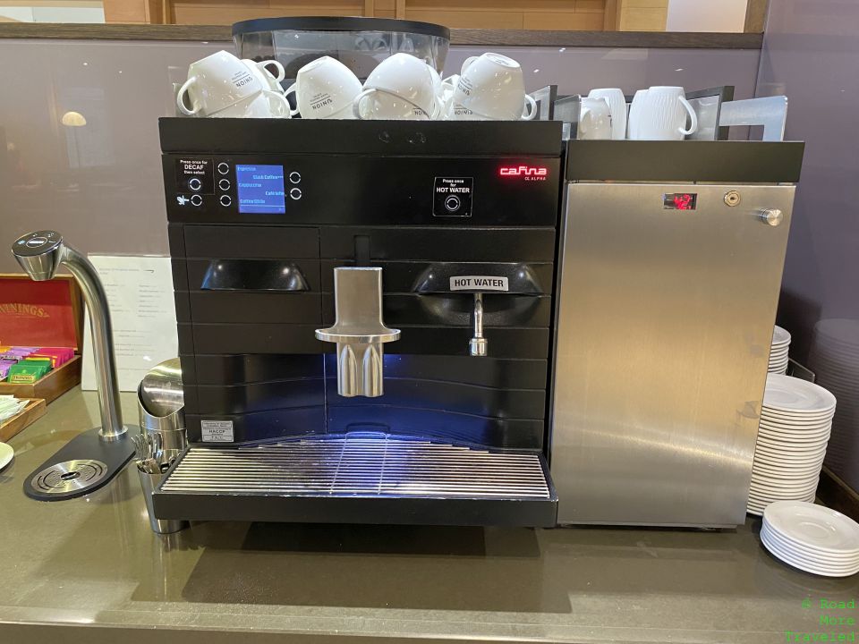 a coffee machine with white cups on top