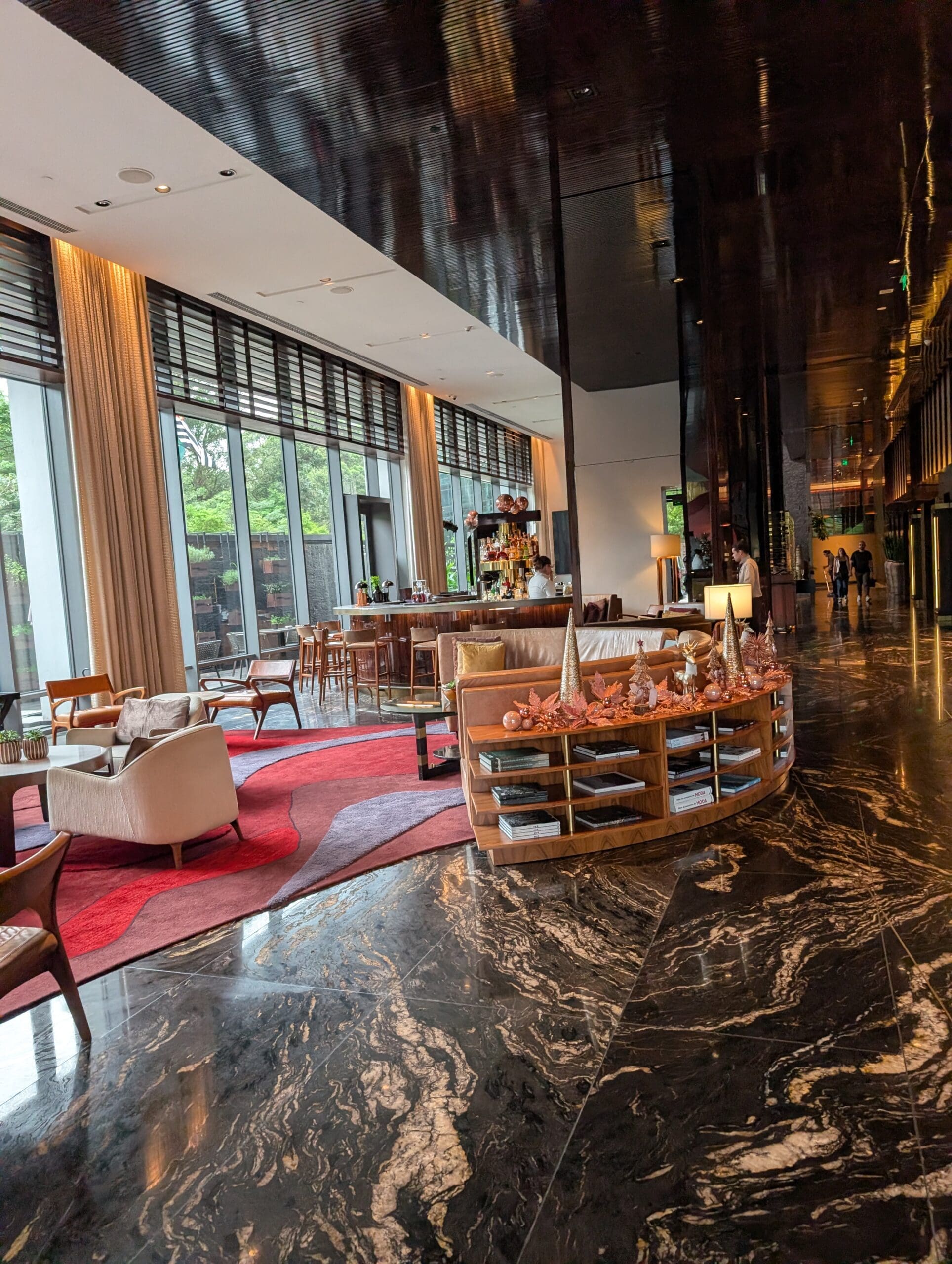 a lobby with a large glass wall and a large table and chairs