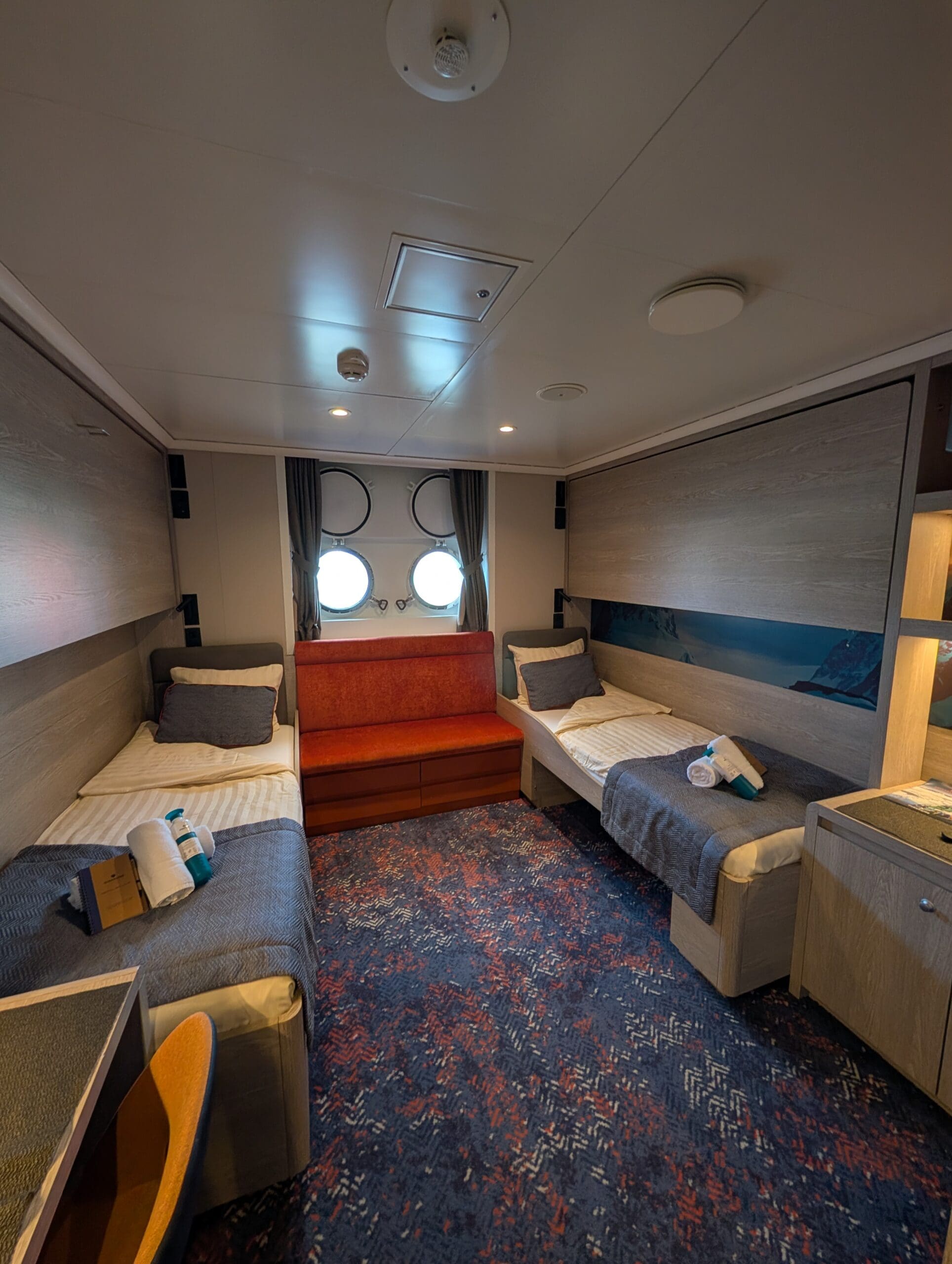 a room with two beds and a window with round windows