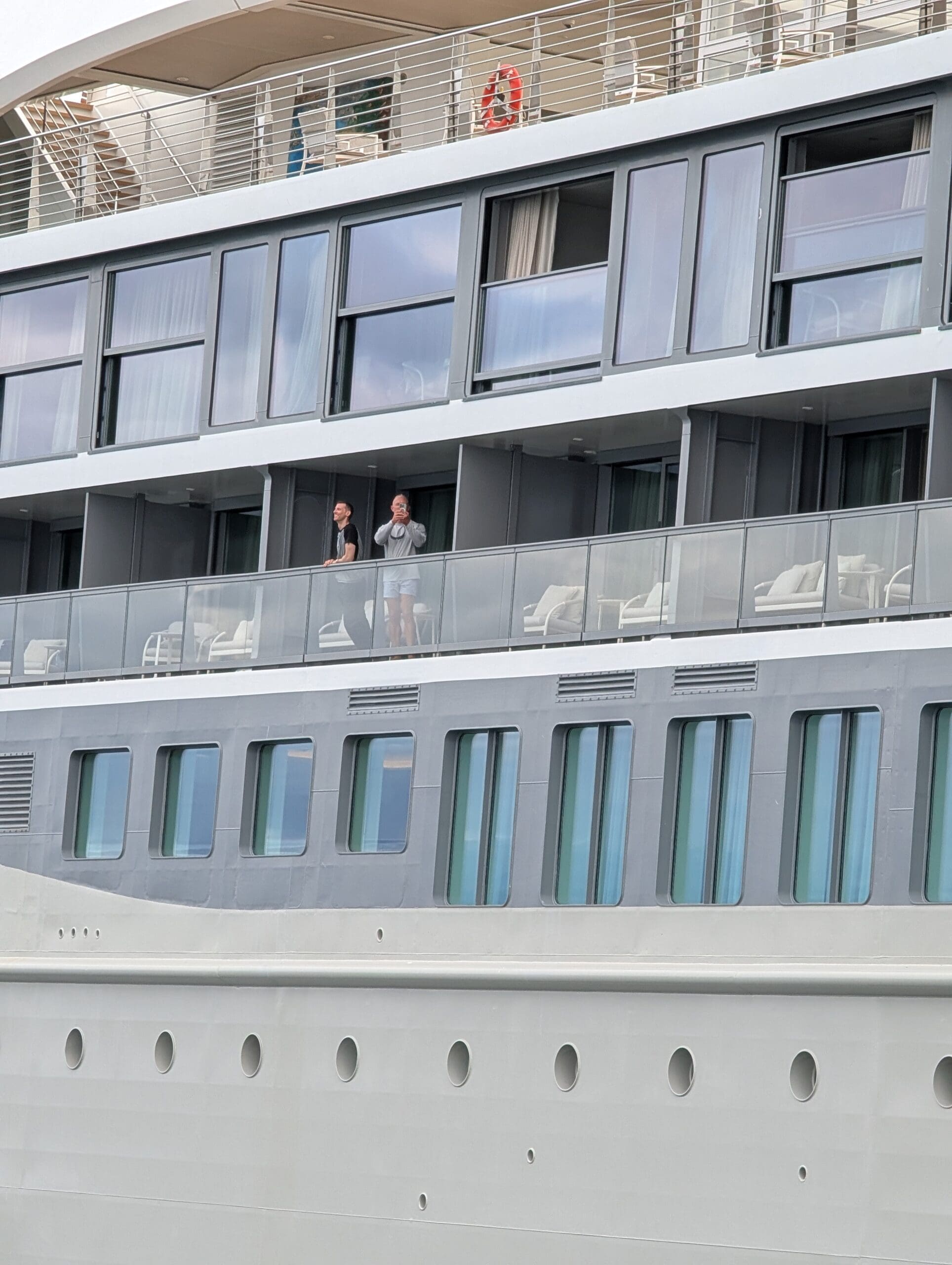a couple of people standing on a balcony of a boat