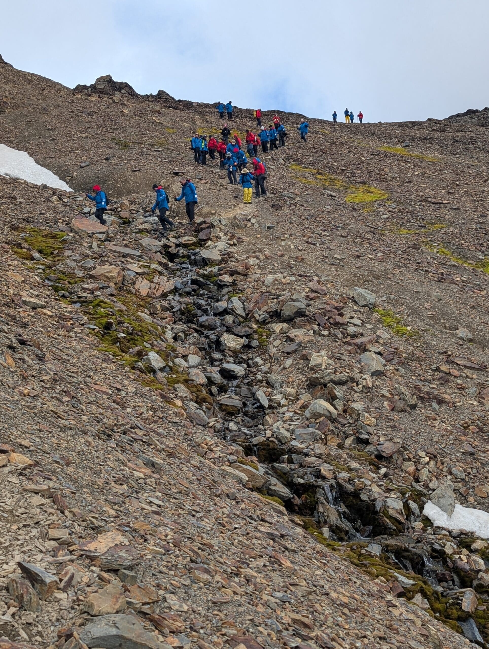 a group of people walking up a rocky mountain