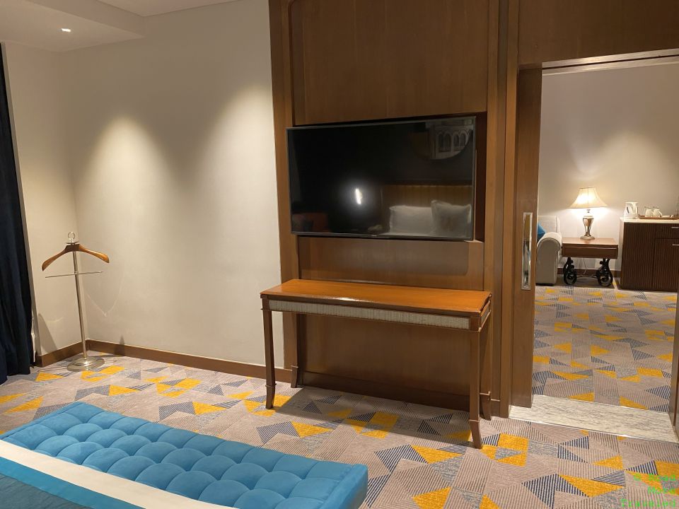 a room with a tv and a blue bench