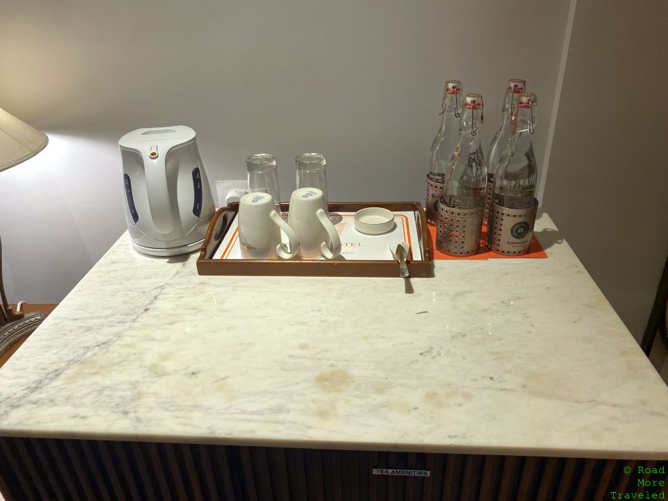 a tray of glass bottles and cups on a marble counter