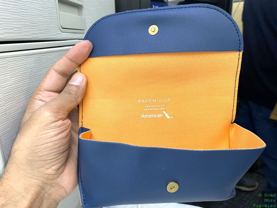 a hand holding a blue and yellow wallet