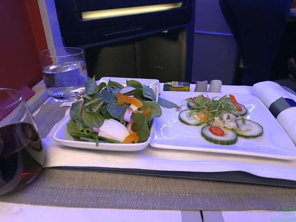 a plate of salad and cucumber on a tray