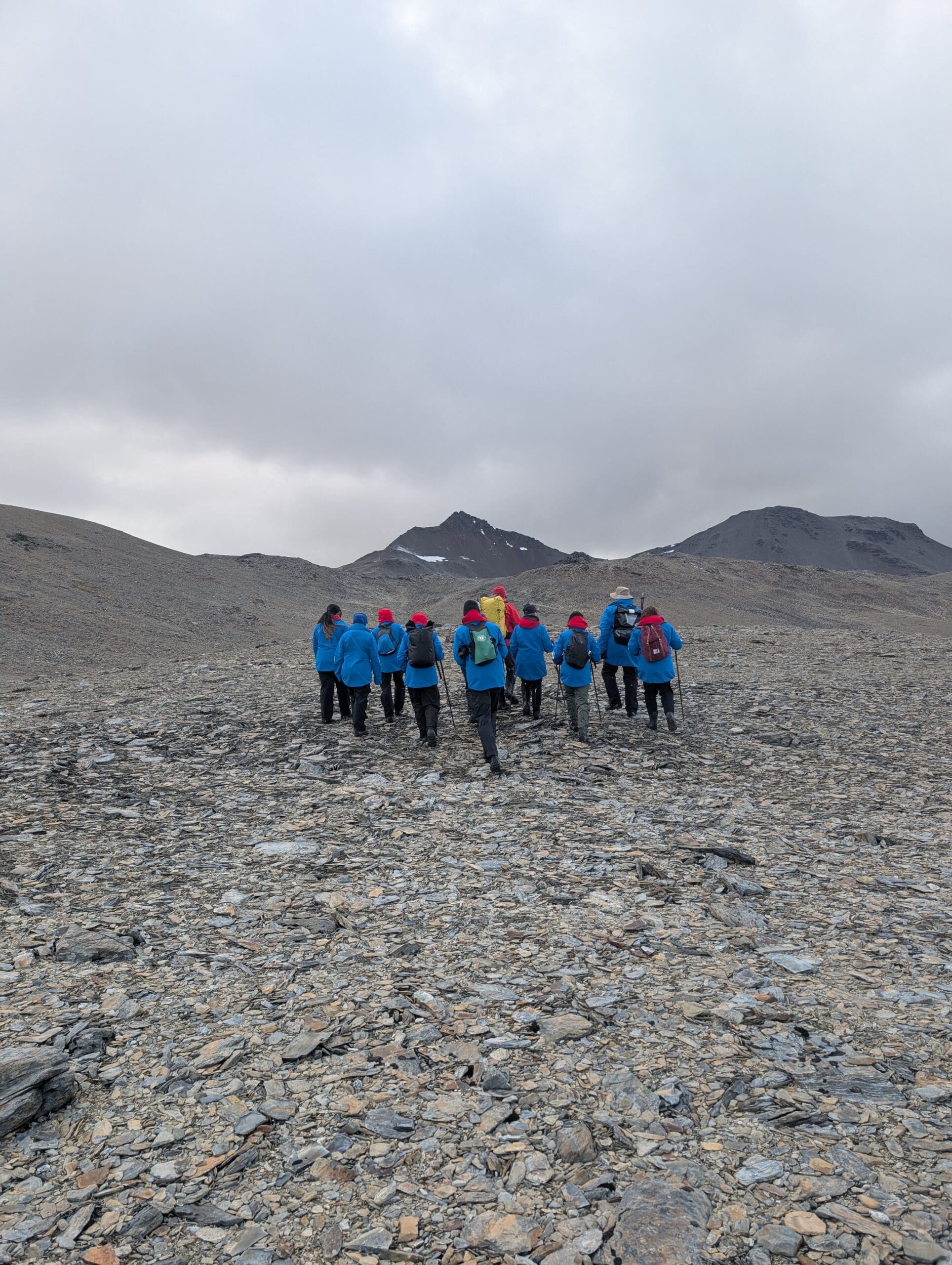 a group of people walking on a rocky mountain